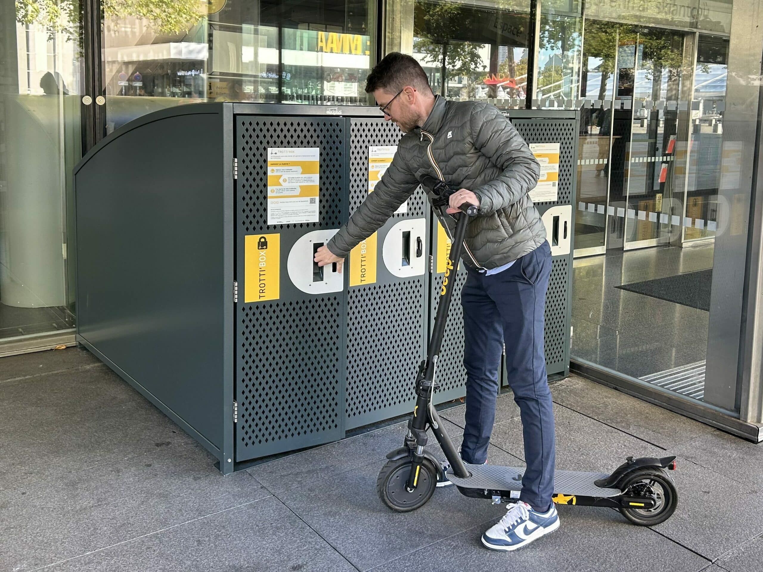 Homme stationnant sa trottinette dans un box sécurisé