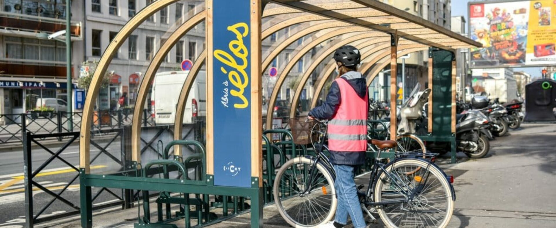 Personne stationnant son vélo sous un abri vélo ouvert Abri Plus